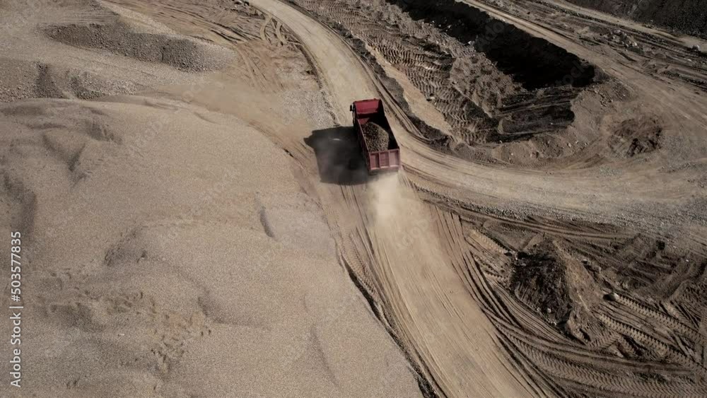 Sand transport from open pit. Dump truck transports sand and gravel in open-pit mine, drone view. Bulk Transport for construction. Earthmoving in quarry. Lorry in opencast. Mining industry concept. Sand transport from open pit. Dump truck transports sand and gravel in open-pit mine, drone view. Bulk Transport for construction. Earthmoving in quarry. Lorry in opencast. Mining industry concept.