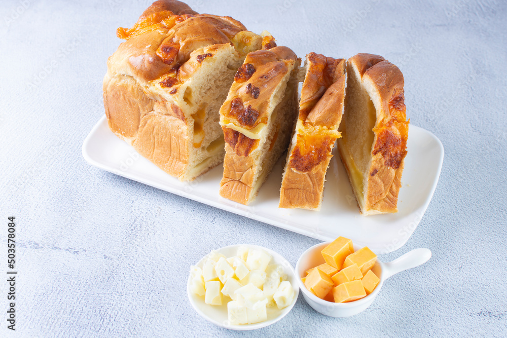3 cheese braid bread, mozzarella, cheese, yellow cheese displayed on gray background 3 cheese braid bread, mozzarella, cheese, yellow cheese displayed on gray background