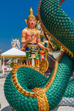 Beautiful shot of the Buddhist Naga and Buddha statues against blue sky in bright sunlight