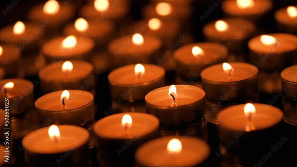 Many small burning candles on a black background Many small burning candles on a black background