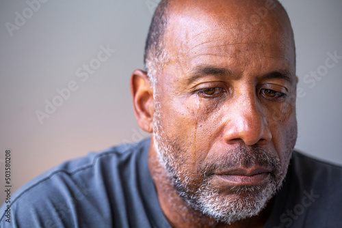 Wall Mural Portrait of a mature man looking sad with tears in his eyes.
