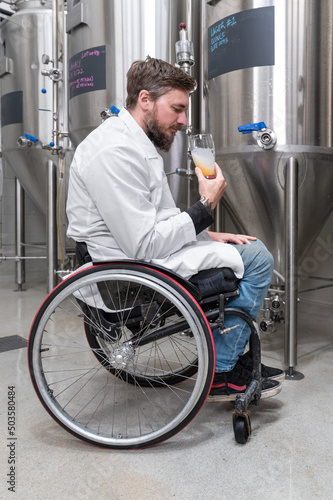Person with disability who uses a wheelchair working at craft beer factory. High quality photography