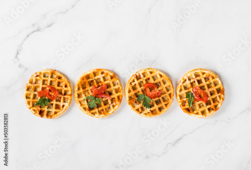 Mini Round waffles pizzas with cheese, ham, tomatoes and parsley. White background. Top view