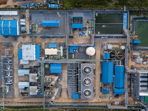 Aerial view of gas turbine power plant factory with cooling system fan in operation that producing electricity while causing pollution and releasing carbon dioxide which create global warming