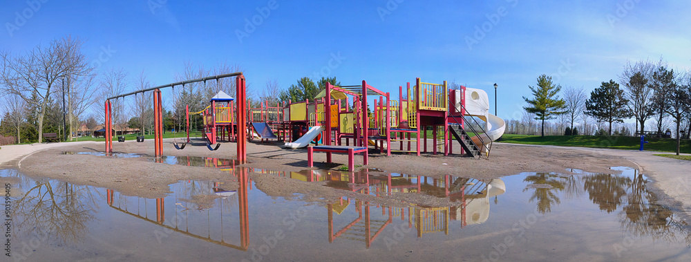 Panoramic view of the playground with reflection at the public park in springtime