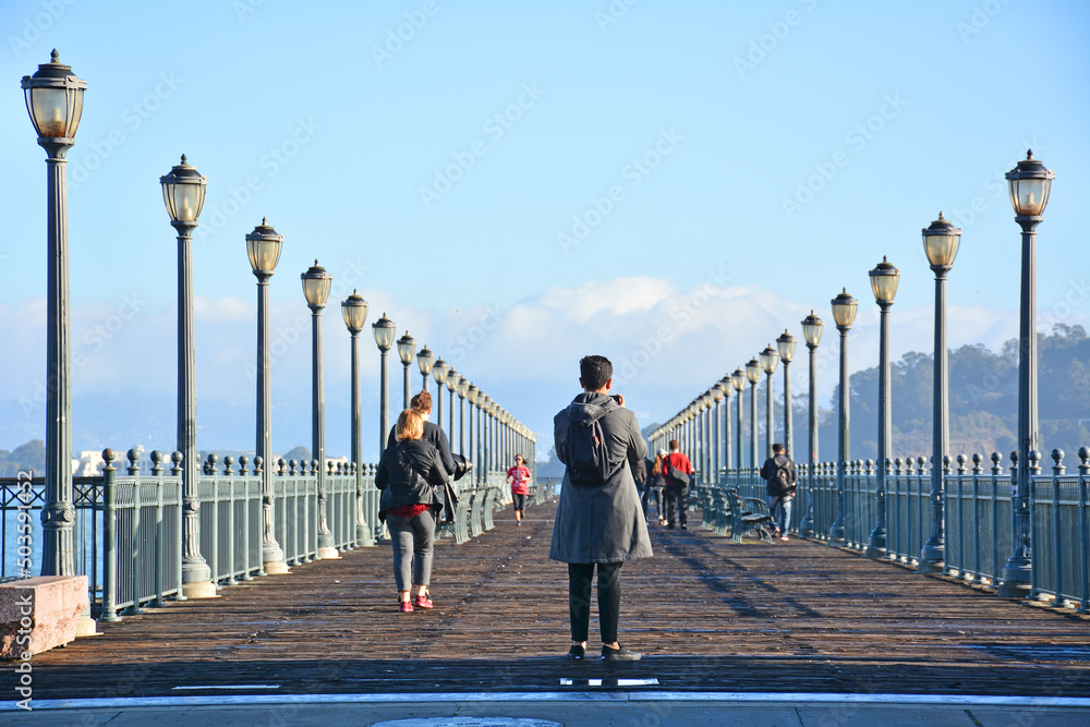 Lamp posts lining a historic wooden pier at the Embarcadero waterfront San Francisco, California