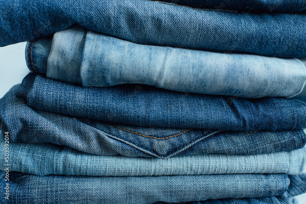 Stack of a stack of old jeans various shades of blue jeans. Denim jeans texture. Denim background texture for design. Canvas denim texture. Stack of a stack of old jeans various shades of blue jeans. Denim jeans texture. Denim background texture for design. Canvas denim texture.