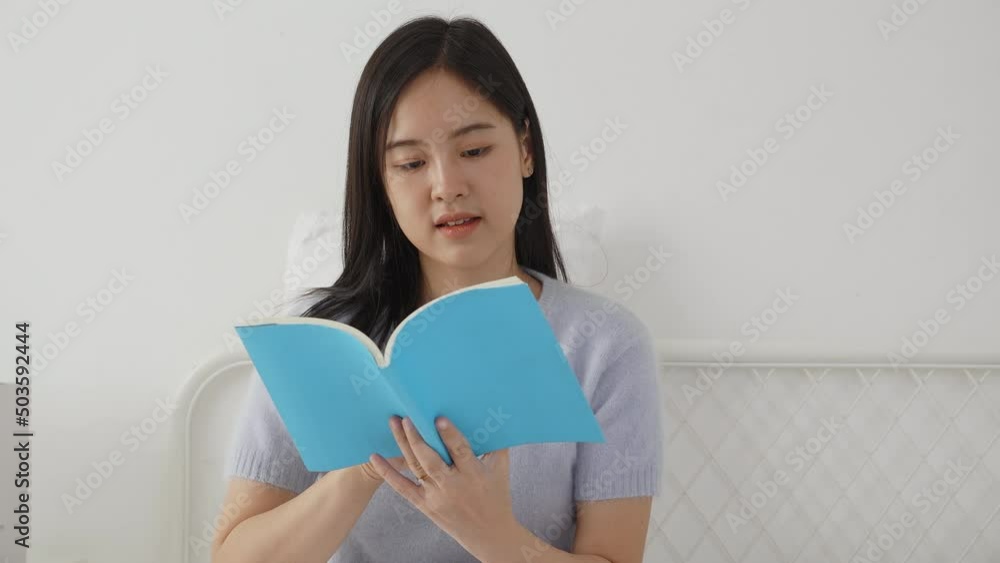 Young asian woman reading a book with relax and cozy on the bed in the bedroom at home, female leisure reading novel while resting with emotional positive, one person, lifestyles concept. Young asian woman reading a book with relax and cozy on the bed in the bedroom at home, female leisure reading novel while resting with emotional positive, one person, lifestyles concept.