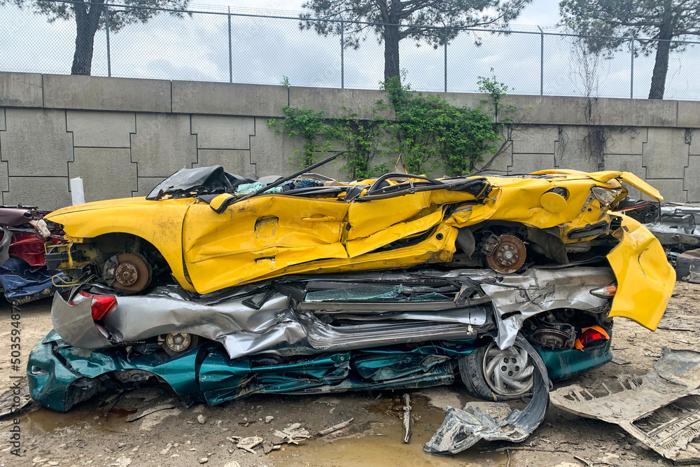Pile of shredded cars to be shredded at a recycling plant, stack of automobiles after road accidents