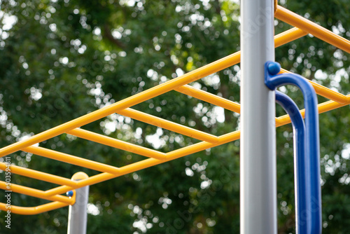 Yellow color monkey bars on a playground.
 photo