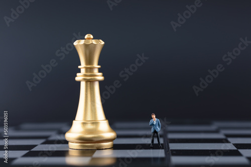 Chess pieces and anxious businessman