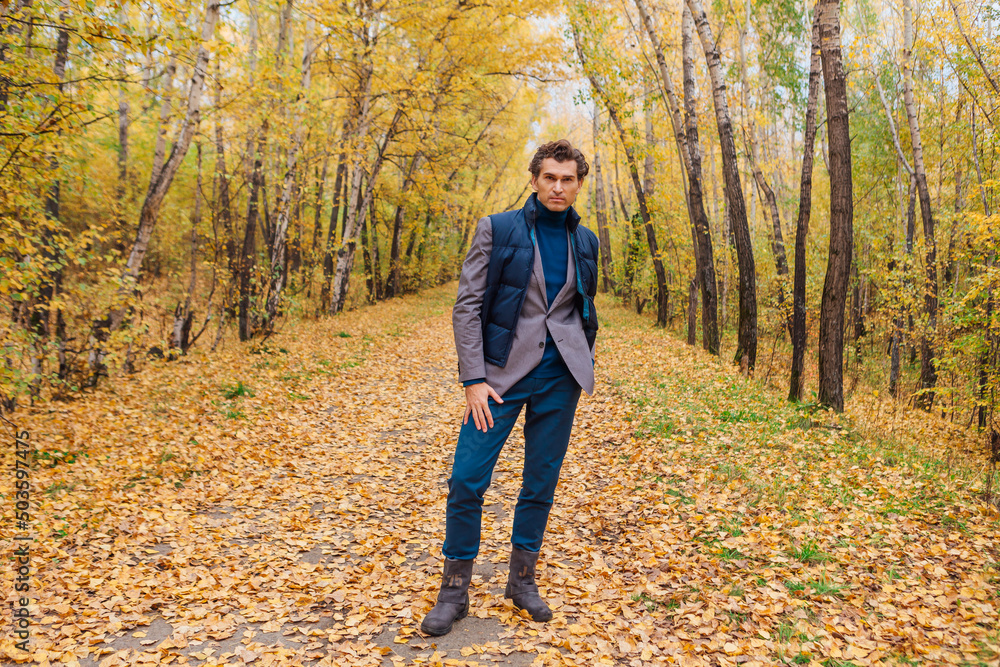 Tall handsome man walking in the autumn alley Tall handsome man walking in the autumn alley