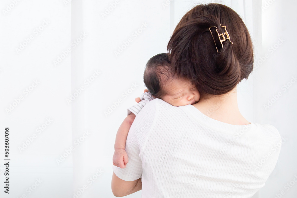 Selective focus Adorable new born 1 month sleeping on her mother's shoulder, Asian mother holding her baby in arm, infant and mother concept, childcare concept. Selective focus Adorable new born 1 month sleeping on her mother's shoulder, Asian mother holding her baby in arm, infant and mother concept, childcare concept.