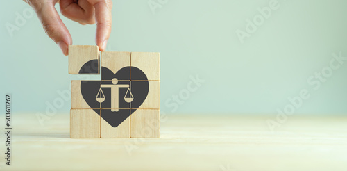Ethical corporate culture concept. Ethics inside human heart. Business integrity and moral. Placing wooden cubes with ethics inside a heart on smart background. Sustainable business development. photo