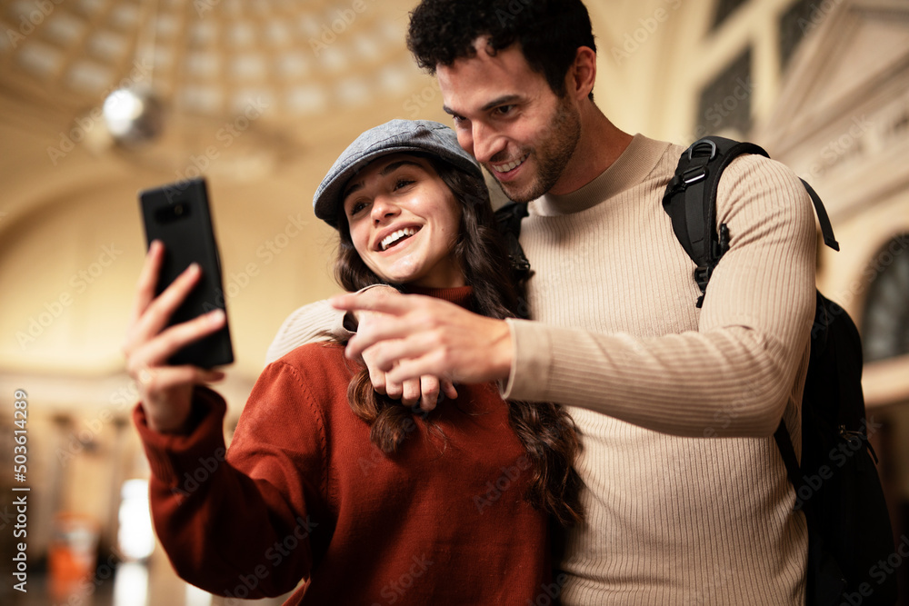 Beautiful couple at railway station waiting for the train. Young woman and man waiting to board a train. Beautiful couple at railway station waiting for the train. Young woman and man waiting to board a train.