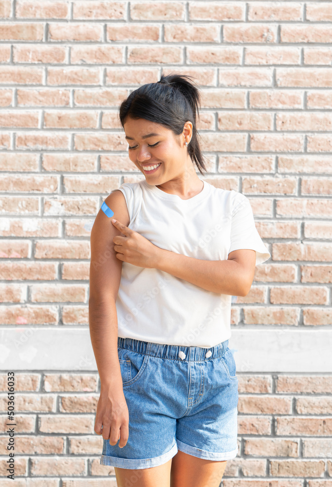 Smiling Latin woman looking at her shoulder after being vaccinated against the Covid 19 flu. Second dose. Smiling Latin woman looking at her shoulder after being vaccinated against the Covid 19 flu. Second dose.