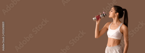 Sporty young woman drinking...