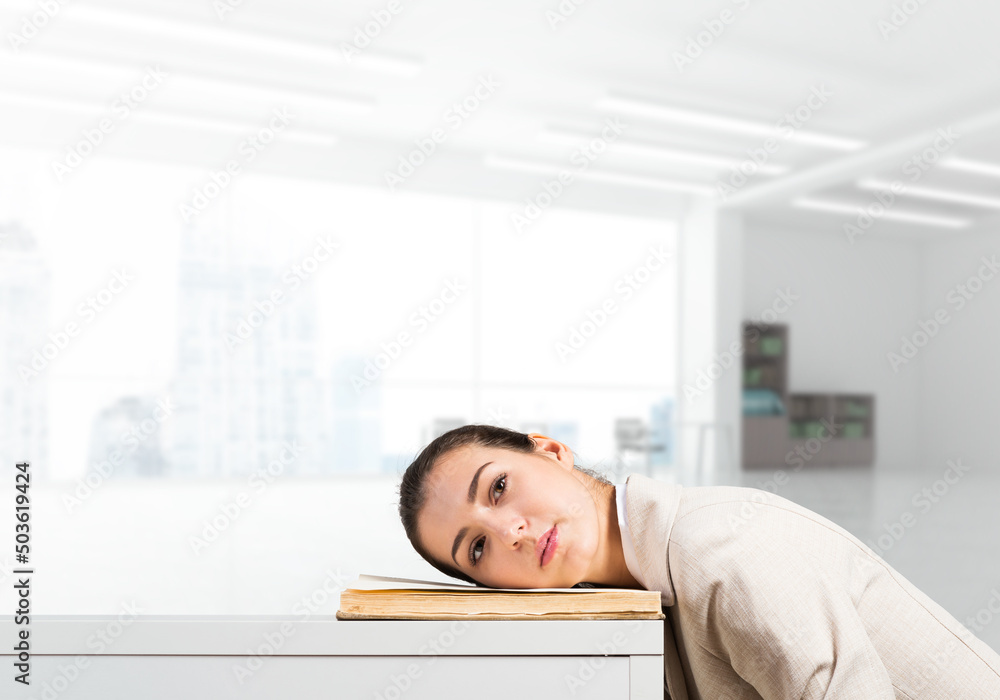 Bored business woman lying on desk Bored business woman lying on desk