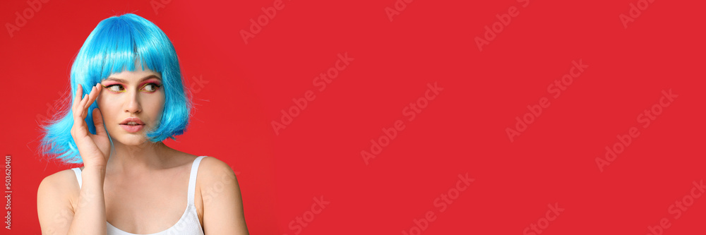 Beautiful young woman in blue wig on red background with space for text Beautiful young woman in blue wig on red background with space for text