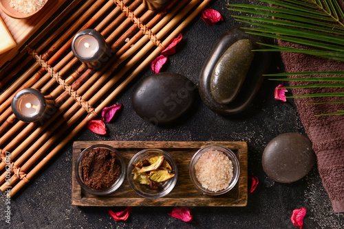 Beautiful spa composition with burning candles and stones on dark background