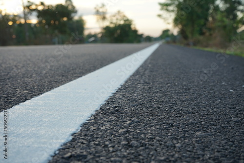 Technicians are marking a traffic line on a paved road.