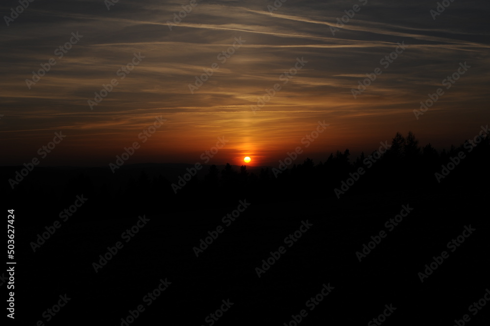 Romantic sunset with orange and yellow sky with clouds in Beskidy mountains in the south of Poland, Europe