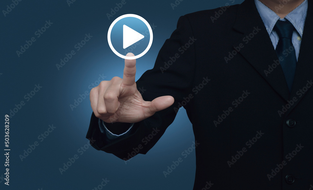 Businessman pressing play button icon over gradient light blue background, Business music online concept Businessman pressing play button icon over gradient light blue background, Business music online concept