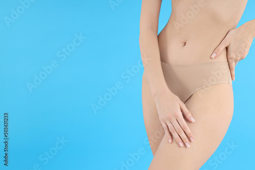Concept of weight loss, young woman body on blue background