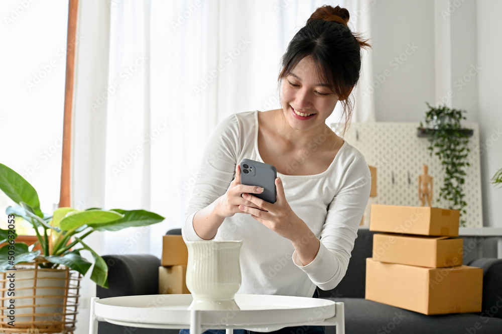 Woman online shop owner using her phone to take a picture of her product for online content. Woman online shop owner using her phone to take a picture of her product for online content.