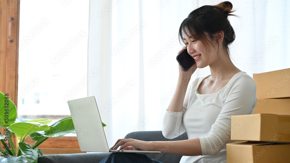 Female business startup entrepreneur talking on the phone with her supplier Female business startup entrepreneur talking on the phone with her supplier