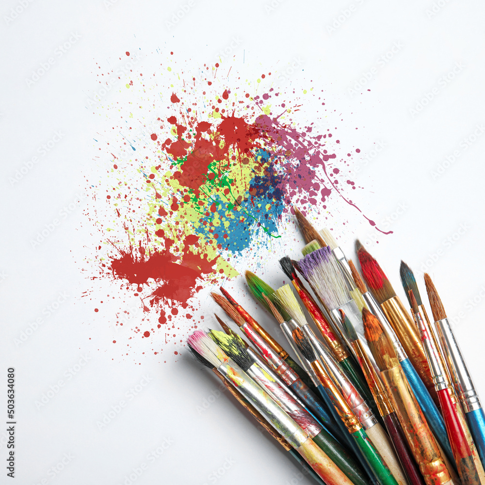 Fototapeta premium Different brushes and paint splatters on white background, top view