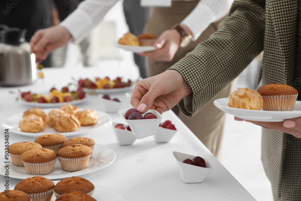 Woman taking snack during coffee break, closeup Woman taking snack during coffee break, closeup