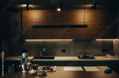 Modern kitchen with black furniture and wooden floor