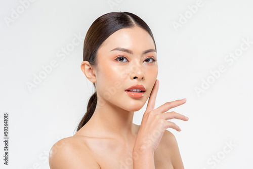 Beauty shot portrait of attractive Asian woman touching smooth skin on cheek in white isolated studio background