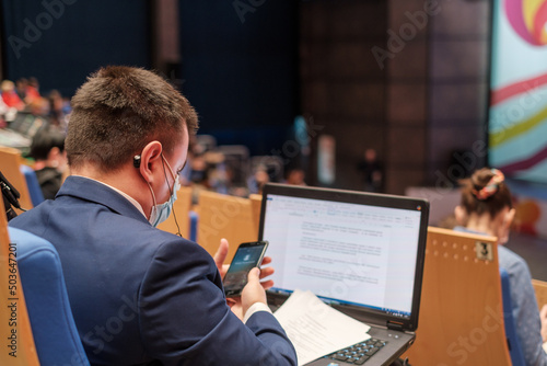 Businessman using laptop during seminar