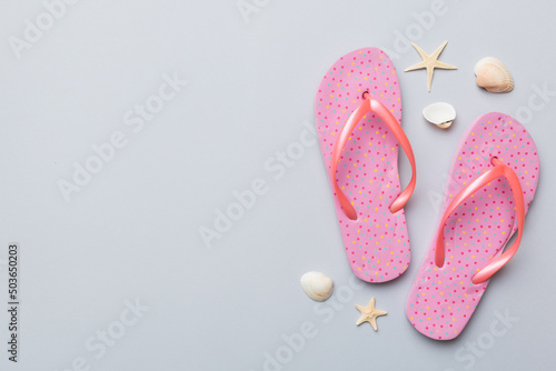 Flat lay composition with flip flops and seashell on colored background. Space for text top view