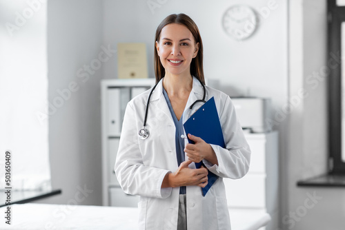 medicine, healthcare and profession concept - smiling female doctor with stethoscope and clipboard at hospital