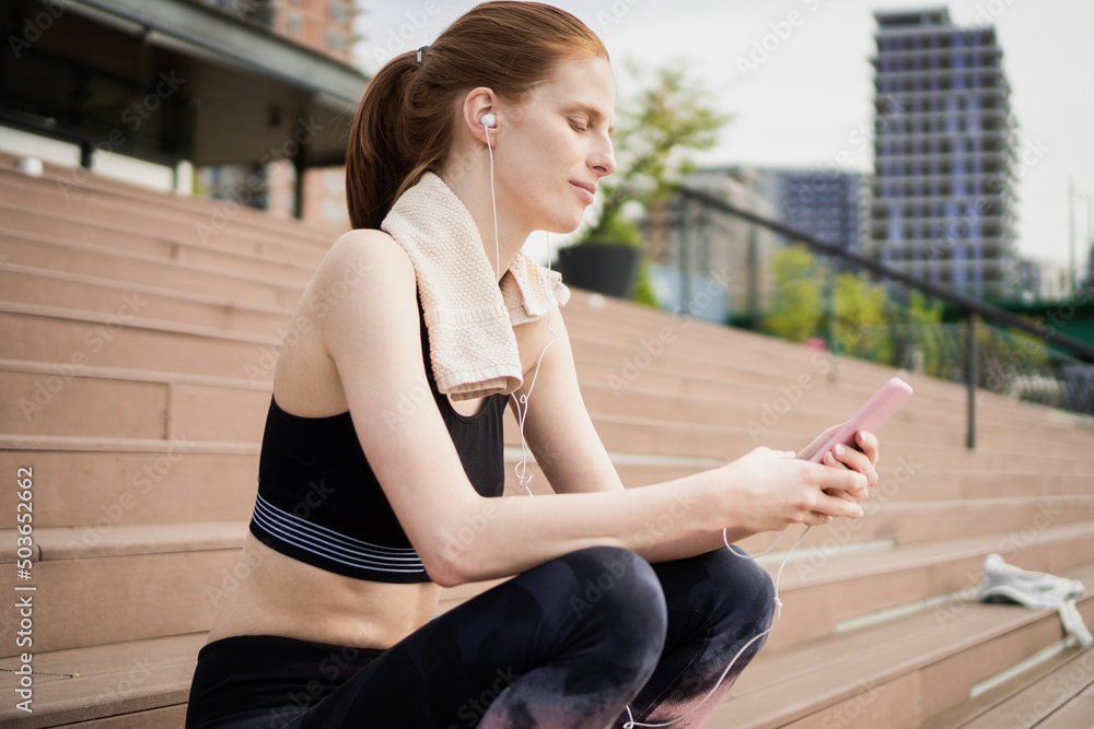 Choosing music for exercise Young Woman Choosing music for exercise Young Woman