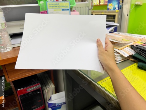 Hand holding blank paper isolated.