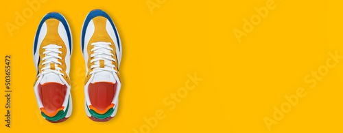 Pair of trendy colorful shoes on yellow background, flat lay top view. Sport sneakers with copy space, Summer footwear concept