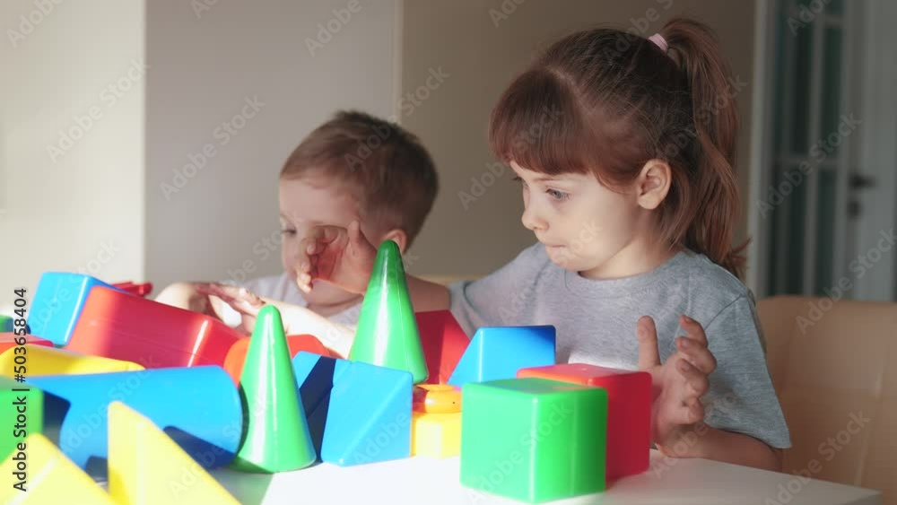 kids girl and baby play in kindergarten. a group of children play toys cubes and cars on the table in kindergarten. happy family preschool education concept. nursery baby toddler indoor home kids girl and baby play in kindergarten. a group of children play toys cubes and cars on the table in kindergarten. happy family preschool education concept. nursery baby toddler indoor home