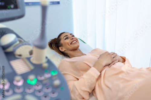 Happy pregnant female visiting women's doctor in the maternity center, doing ultrasound scan, worried about the health of the child, healthy motherhood concept photo