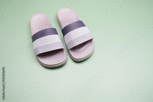 Gray slide sandal summer slippers on green background