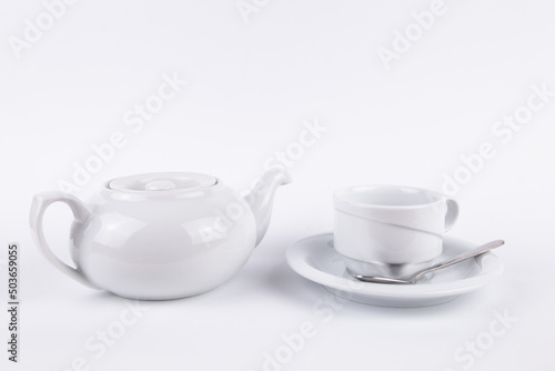 white porcelain teapot and cup on saucer for coffee or tea empty