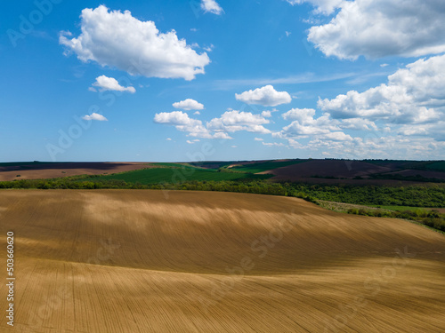 Aerial view of beautiful colorful fields with blue sky and white clouds