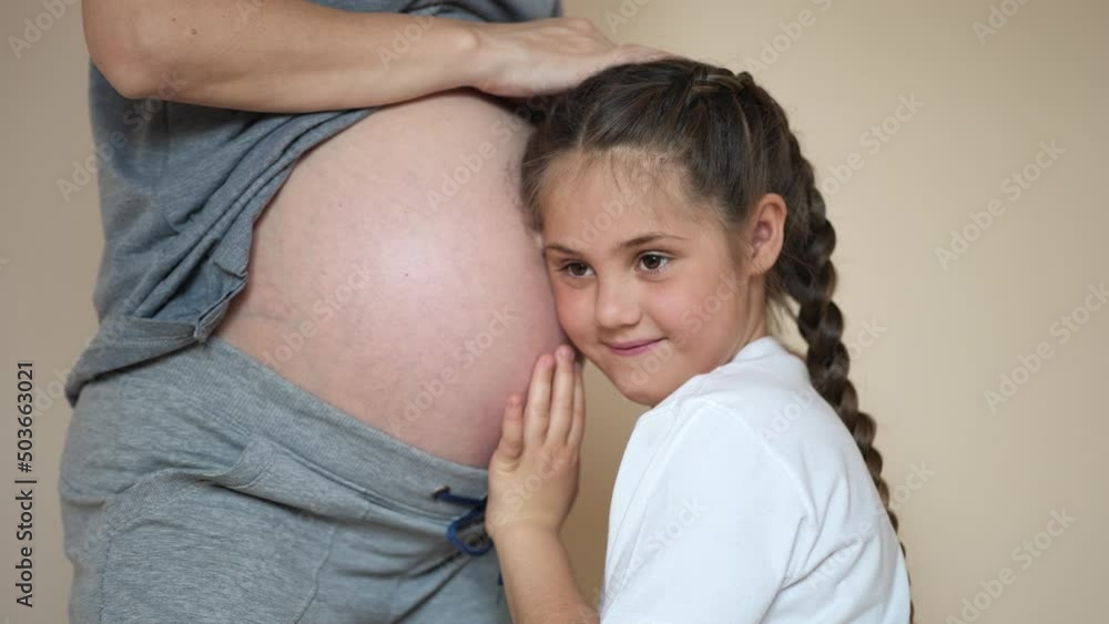 little girl hugs her mother belly. happy family kid pregnancy newborn concept. the daughter sent her ear lifestyle to the belly of the pregnant mother listens to the thrusts of the newborn dream little girl hugs her mother belly. happy family kid pregnancy newborn concept. the daughter sent her ear lifestyle to the belly of the pregnant mother listens to the thrusts of the newborn dream