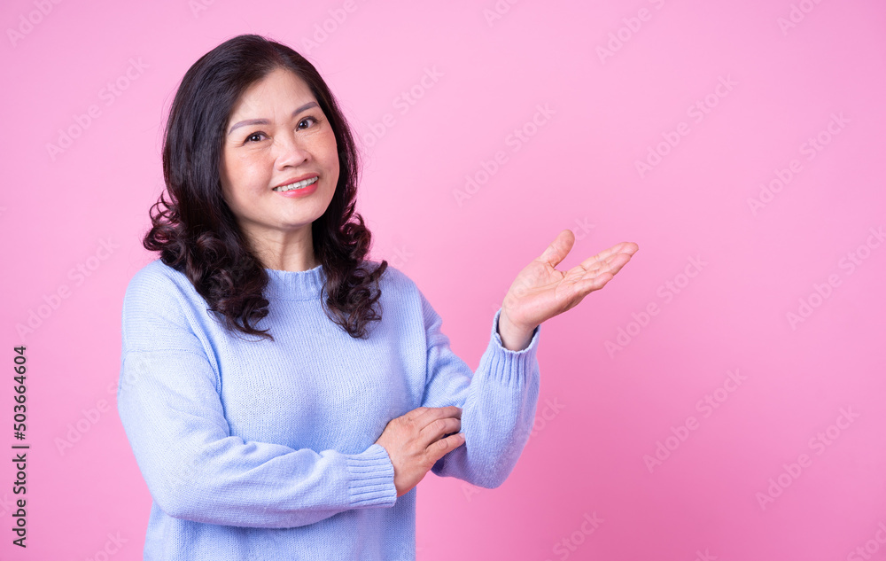 Portrait of middle aged Asian woman on pink background
Portrait of middle aged Asian woman on pink background