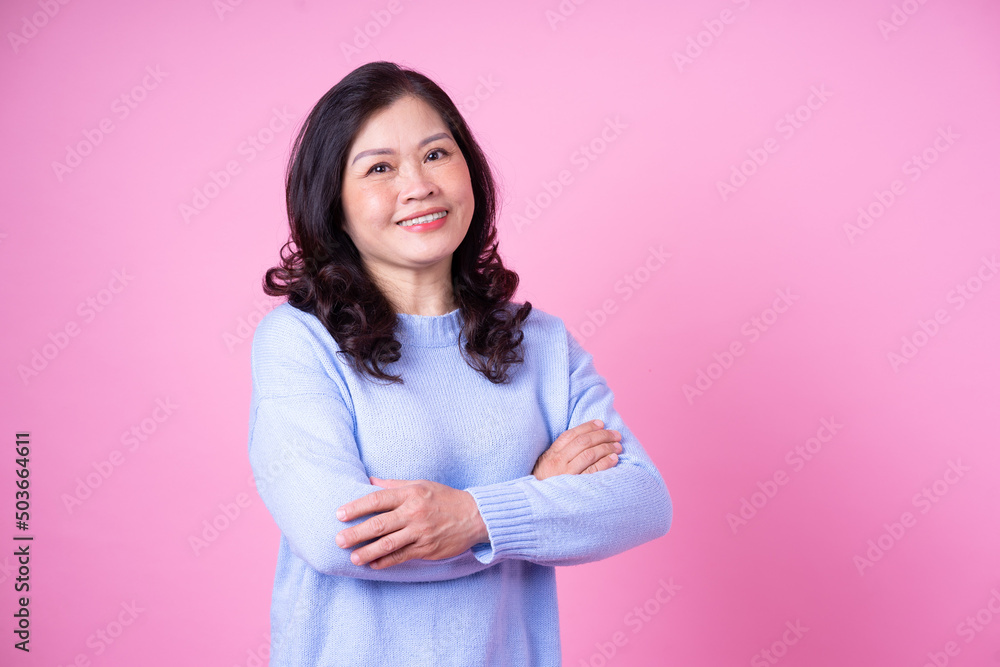 Portrait of middle aged Asian woman on pink background
Portrait of middle aged Asian woman on pink background