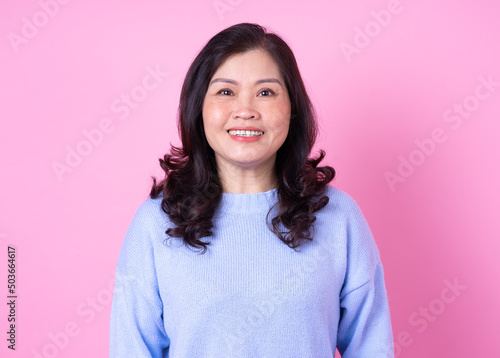 Obraz na plátně Portrait of middle aged Asian woman on pink background