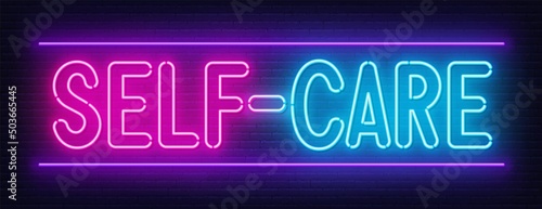 Self Care neon sign on brick wall background.